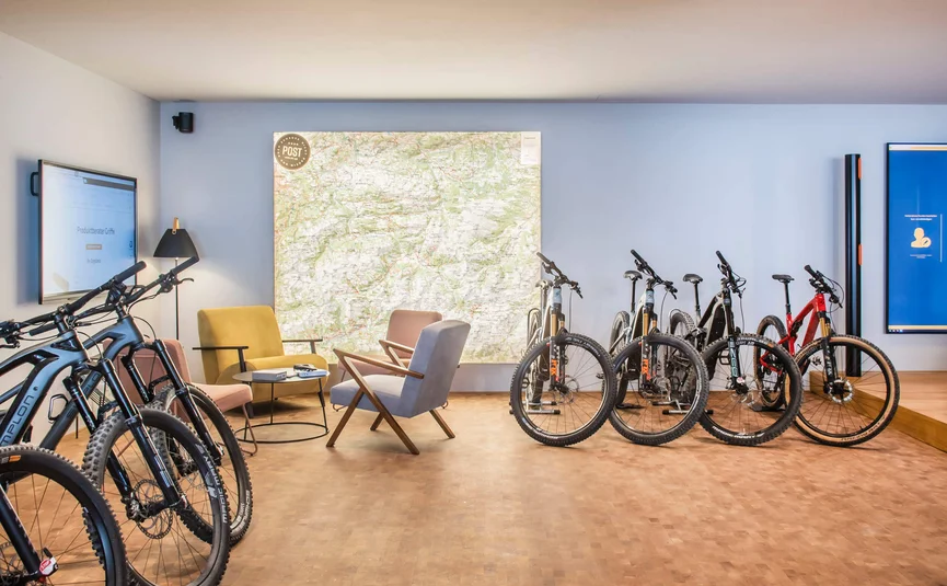 Moderner Raum mit Fahrrädern, Sesseln und großer Wandkarte