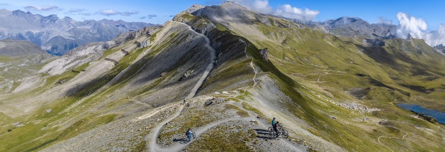 Hotel Weisses Lamm **** © TVB Paznaun-Ischgl Mountainbiker auf einem Höhenweg in alpiner Landschaft bei klarem Himmel