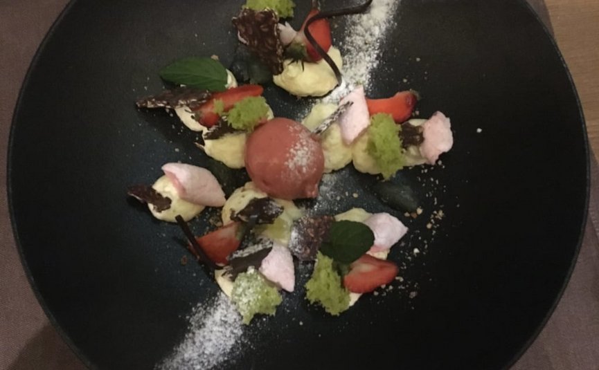 4 day relax-enjoy-skiing on the sunny side of the Zugspitze Artfully plated dessert with strawberry sorbet, cream, and mint leaves on black plate