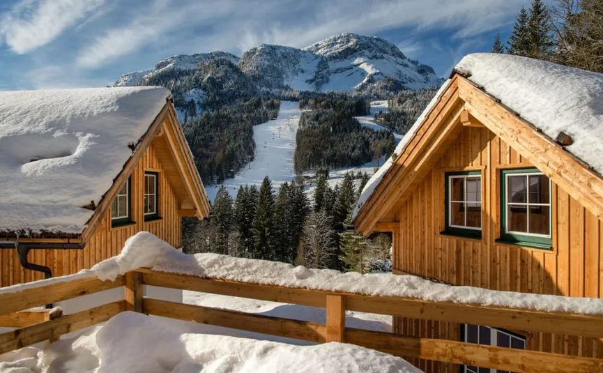 Mid Week 4 Nächte Verschneite Holzhäuser mit Blick auf eine Skipiste und bewaldete Berge