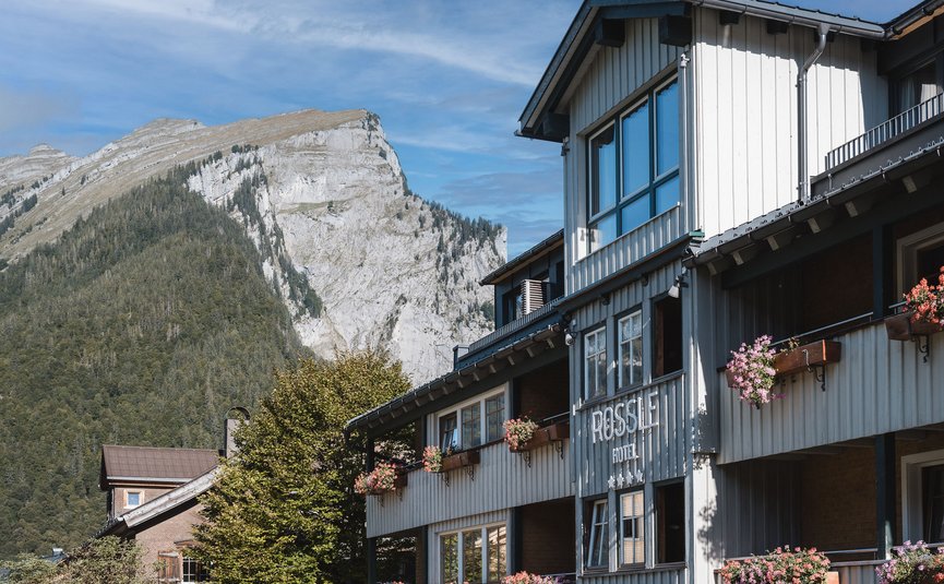 Hotel Rossli with blooming flowers against mountain and blue sky