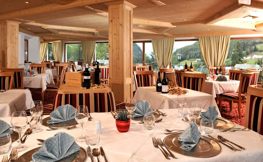 Elegant restaurant met gedekte tafels en panoramisch uitzicht op de bergen