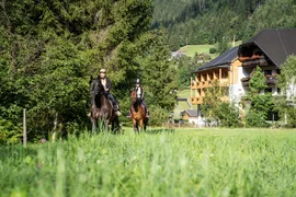 Riding holiday at the GUTshof / 3 nights Two riders on horses in green countryside near a hotel