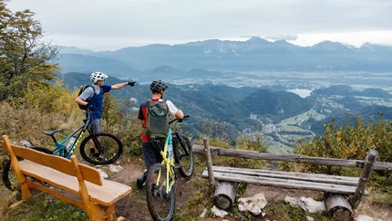 Zwei Radfahrer auf Berg mit Blick auf Tal und Berge