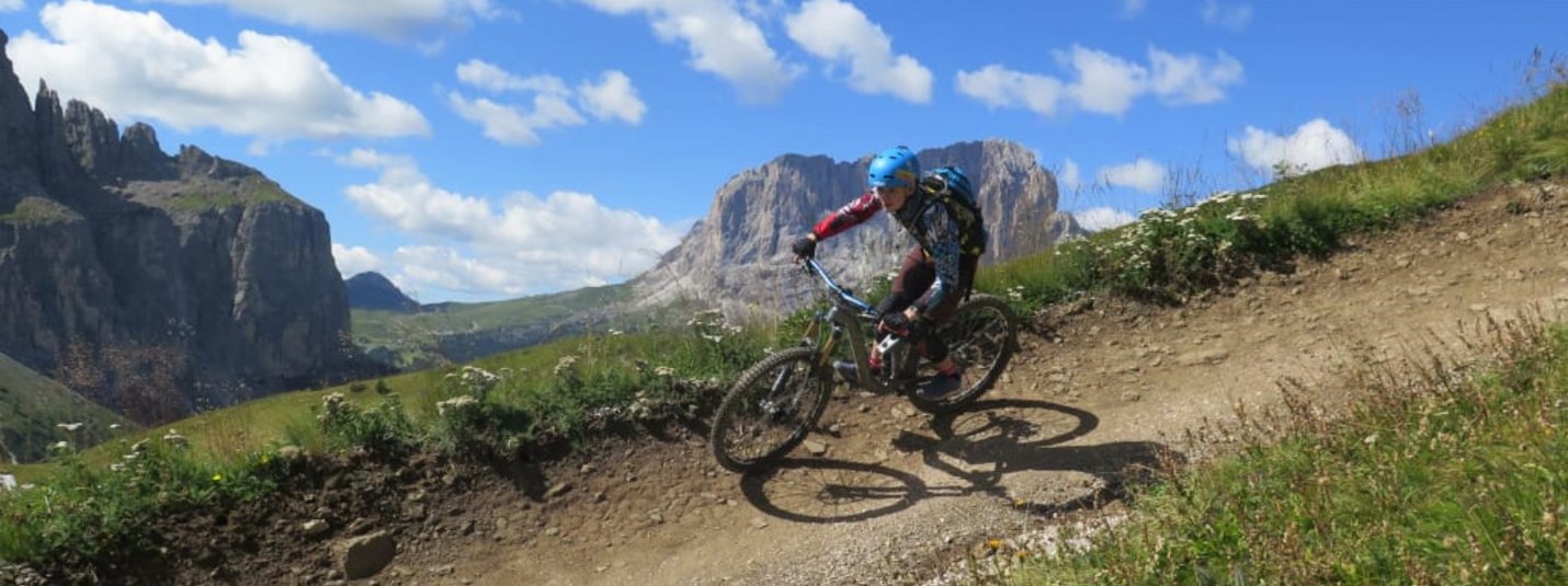 Mountainbiker fährt auf kurvigem Bergpfad bei sonnigem Wetter