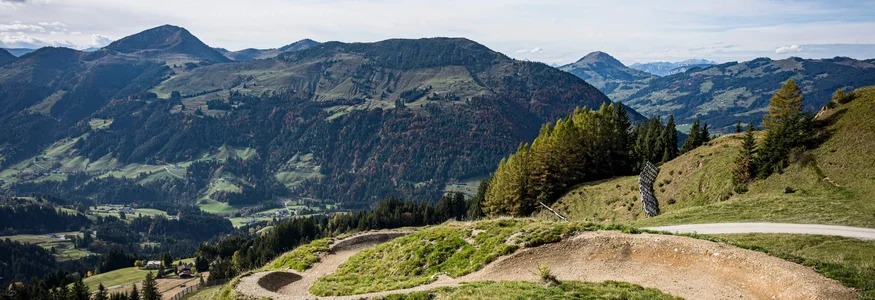 Neuer Flow im Brixental: Der Kirchberg Trail eröffnet © Stromberg Mountainbike-Trail mit Bergen und blauem Himmel im Hintergrund