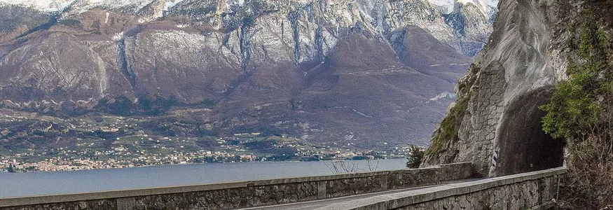 Unterwegs auf der Bond-Straße © Tobias Köhler Steinerne Brücke führt zu einem Tunnel mit bergen und See im Hintergrund
