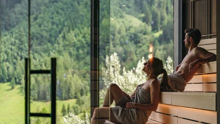 Paar entspannt in Sauna mit Bergblick