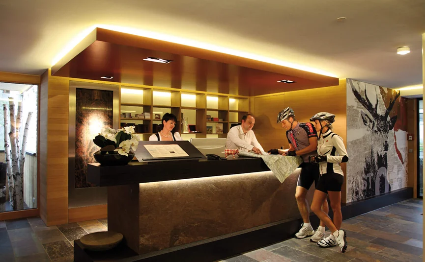 Zwei Radfahrer fragen an der Rezeption nach einer Wegbeschreibung