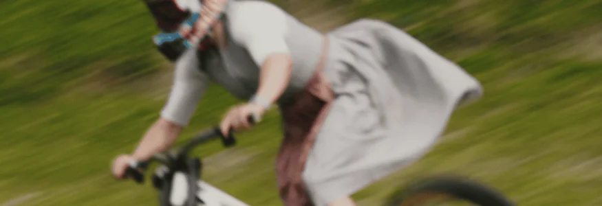 Person in traditioneller Kleidung fährt Fahrrad bergab