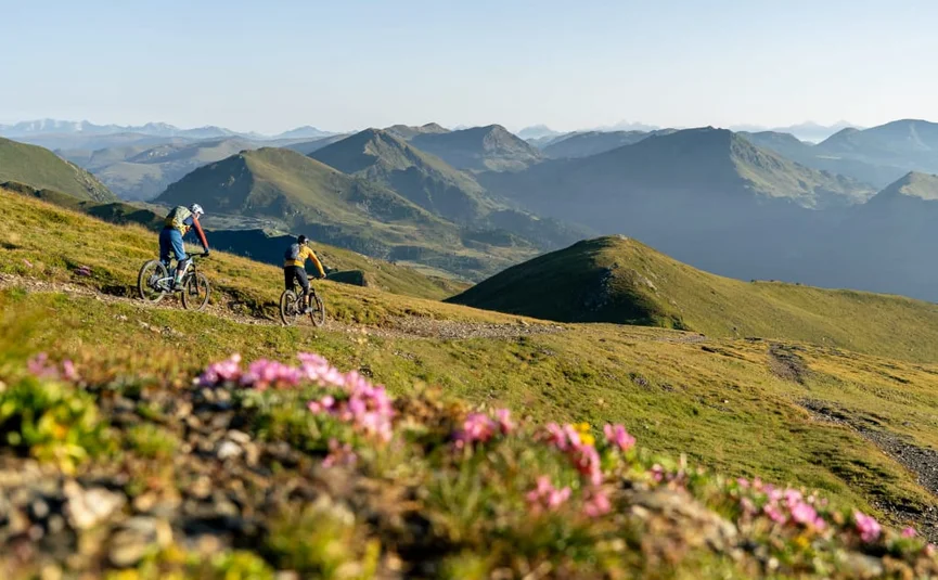 Bike & Wellness - 3 nights Two mountain bikers riding on a trail with alpine mountain views