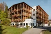 Hotel Melodia del Bosco mit Holzfassade und Blumen auf Balkonen im Grünen