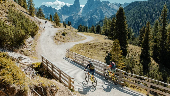 Spätsommer- & Herbstbiken in Toblach © David Karg Zwei Mountainbiker überqueren eine Brücke auf einem Bergweg