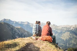 4 Tage Bergsommer rund um die Zugspitze 2026 Twee wandelaars zitten op een berg met rugzakken uitkijkend over bergen