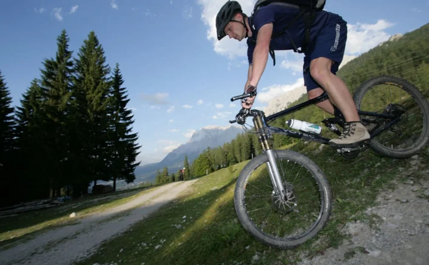 Man mountain biking downhill on a steep mountain trail