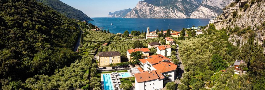 Landschaft mit Häusern, Pool, Bergen und See im Hintergrund