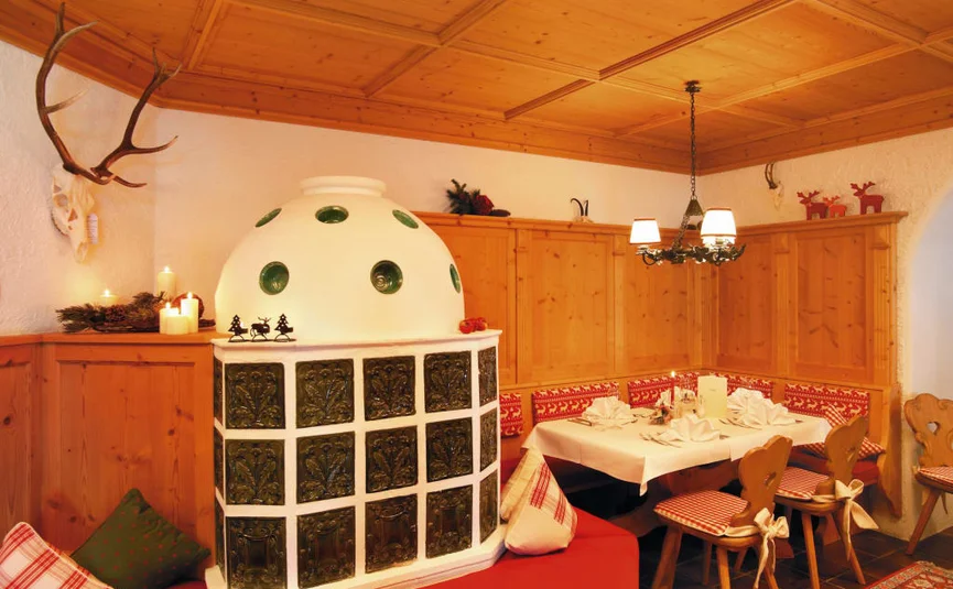 Traditional Tyrolean room with tiled stove and wooden ceiling