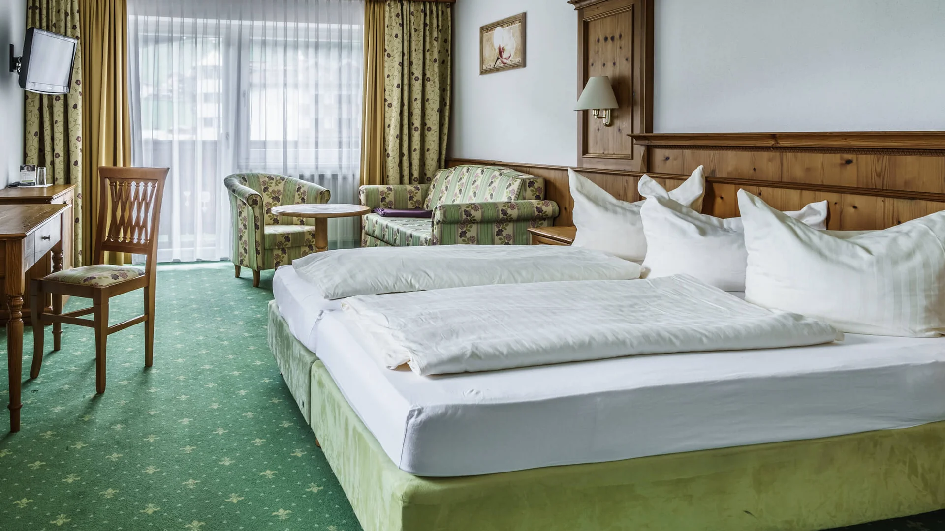 7 gute Gründe für deinen Mountainbikeurlaub im Zillertal
© Almhof Lackner GmbH Gemütliches Hotelzimmer mit grünem Teppich und Holzmöbeln