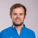 Mann in blauem Mountain-Bike-Shirt und Jeans vor grauem Hintergrund