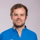Mann in blauem Mountain-Bike-Shirt und Jeans vor grauem Hintergrund