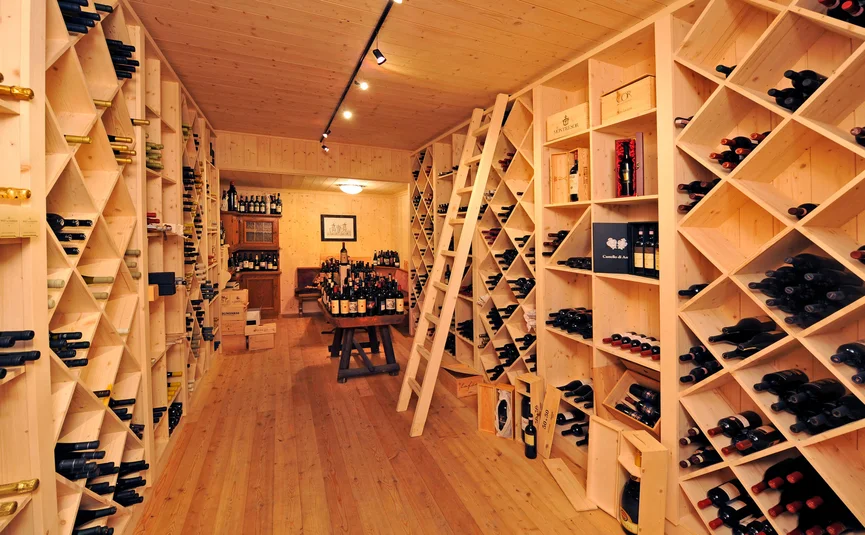 Wijnkelder met houten rekken vol wijnflessen en houten dozen
