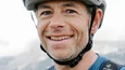 Mann mit Fahrradhelm und Rucksack vor Bergpanorama