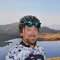 Radfahrer vor Bergsee und Gipfel im Sonnenlicht