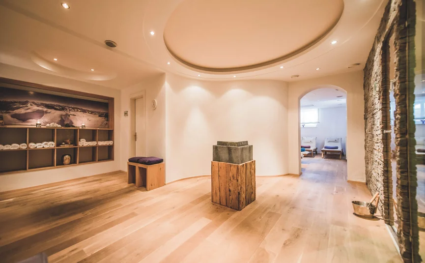Heller Wellnessraum mit Holzfußboden und Ruhebereich mit Liegestühlen