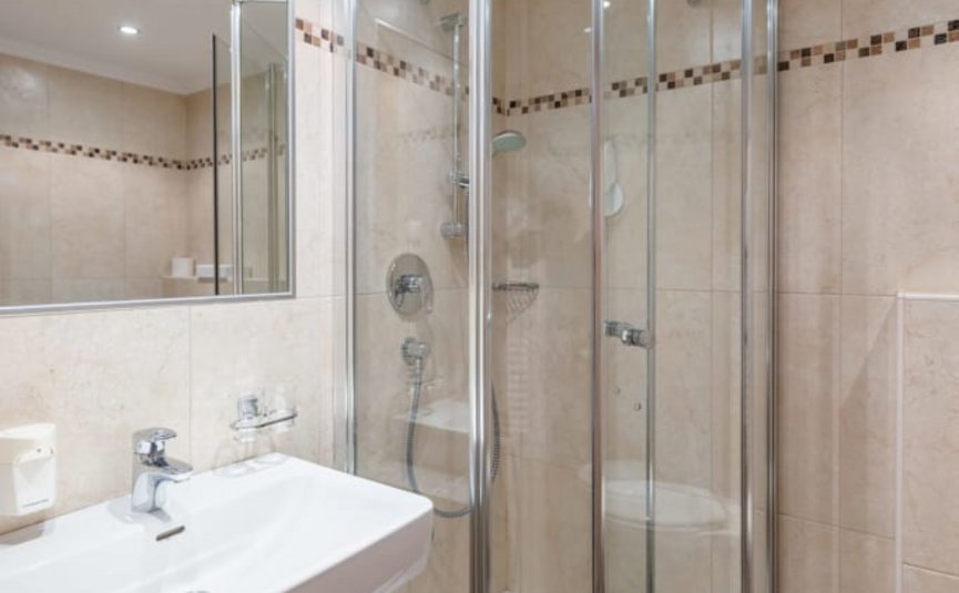 Modern bathroom with corner shower and wall-mounted sink