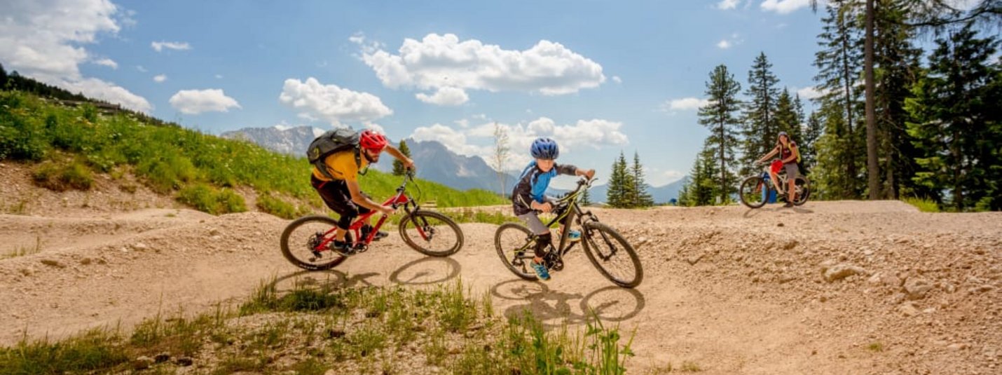 Two mountain bikers riding on a dirt trail in the mountains