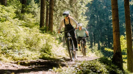 Bike-Region Flachau – von Radabenteuer bis Signature Ride © Flachau Tourismus - Simon Reisinger Zwei Personen fahren Mountainbike auf einem Waldweg