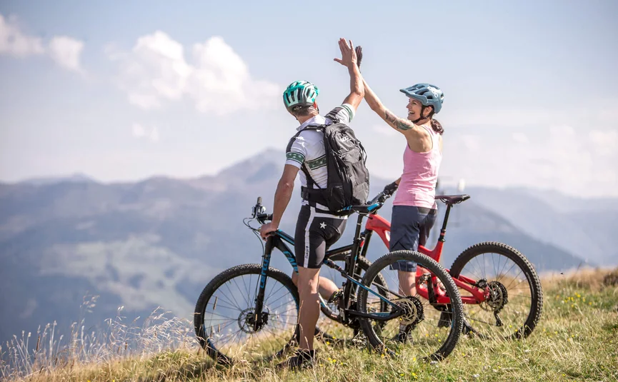 Twee mountainbikers geven elkaar een high-five op een berg