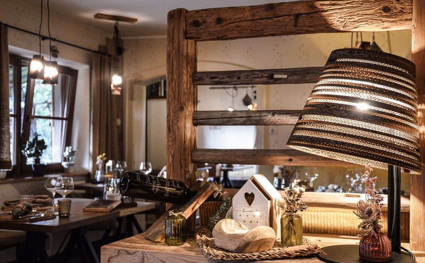 Gemütliche Innenraumdekoration mit Holz, Lampe und Weinglas im Restaurant