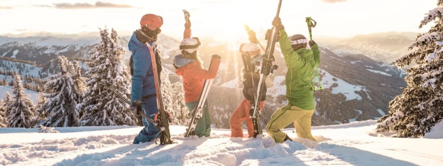 Short Stay - 4 Nächte mit 3-Tages-Skipass Vier skiërs vieren op besneeuwde berg bij zonsondergang