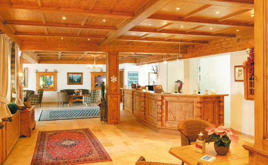 Cozy wooden hotel lobby with reception desk and seating areas