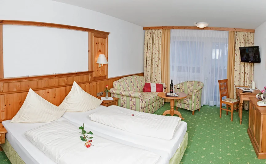 Hotelkamer met twee eenpersoonsbedden, bank, tafel en tv