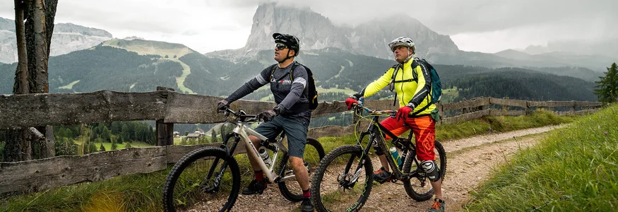 Twee mountainbikers op een pad met berglandschap op de achtergrond