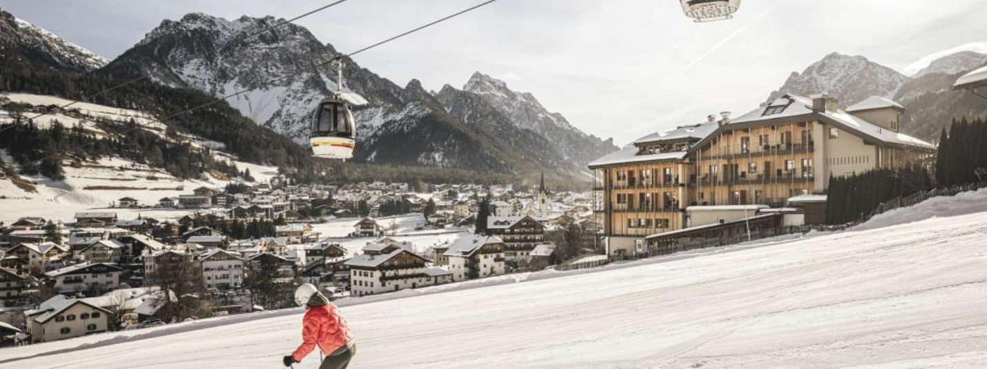Dolomiti Spring Days L | 14=12 Skieën naar beneden bij bergdorp en kabelbaan gondels in de sneeuw