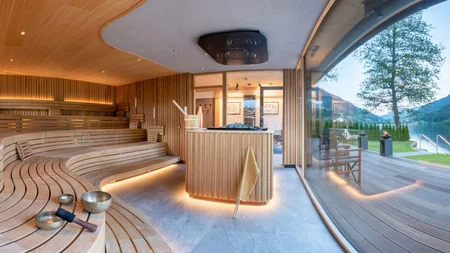 Modern sauna with wooden benches and view of lake and mountains