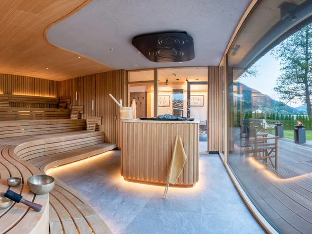 Modern sauna with wooden benches and view of lake and mountains