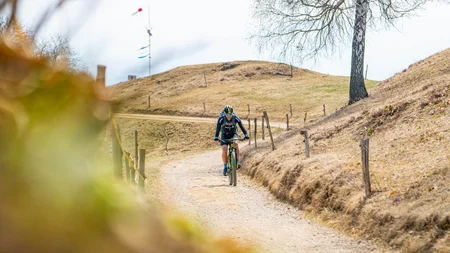 Mountainbiker auf einem kurvigen Weg im trockenen, hügeligen Gelände