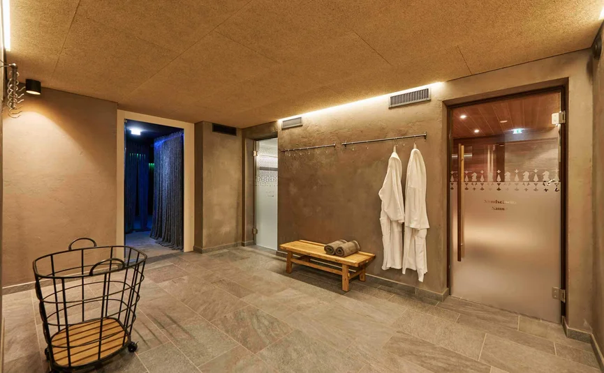 Ontspanningsruimte met badjassen bij saunadeur in wellnesscentrum