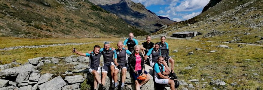 Gruppe von Radfahrern auf einer Pause in den Bergen bei sonnigem Wetter