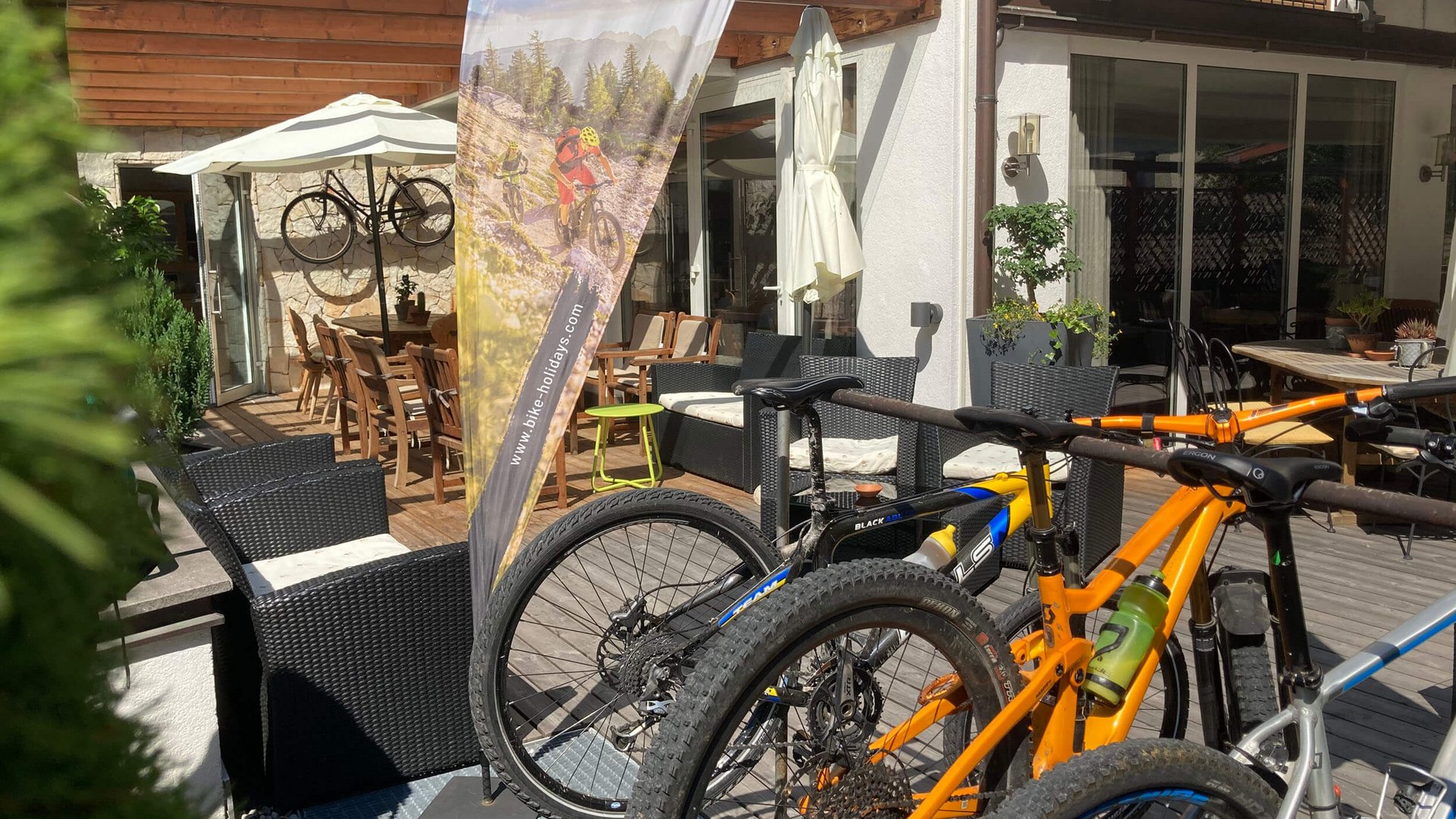 Mountainbikes vor Lodge mit Mountain Bike Holidays Fahne
