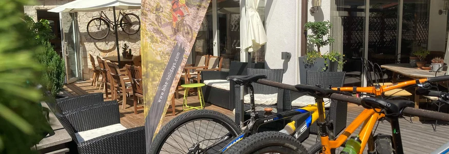 Mountainbikes vor Lodge mit Mountain Bike Holidays Fahne