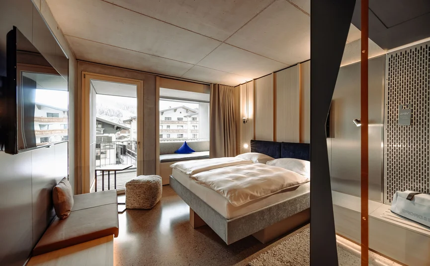 Moderne hotelkamer met tweepersoonsbed en balkon met bergzicht