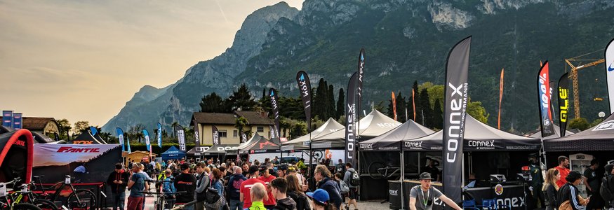 Menschen auf einer Fahrradmesse mit Bergen im Hintergrund