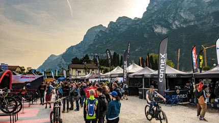 Menschen auf einer Fahrradmesse mit Bergen im Hintergrund