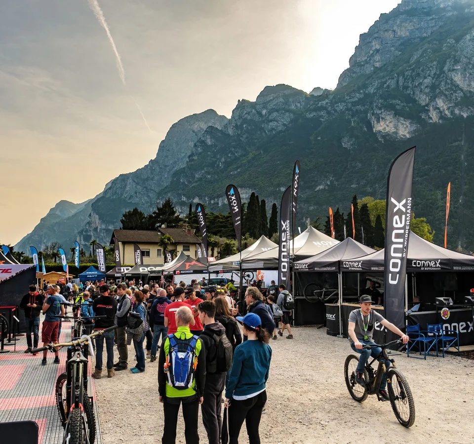 People at a bike fair with mountains in the background