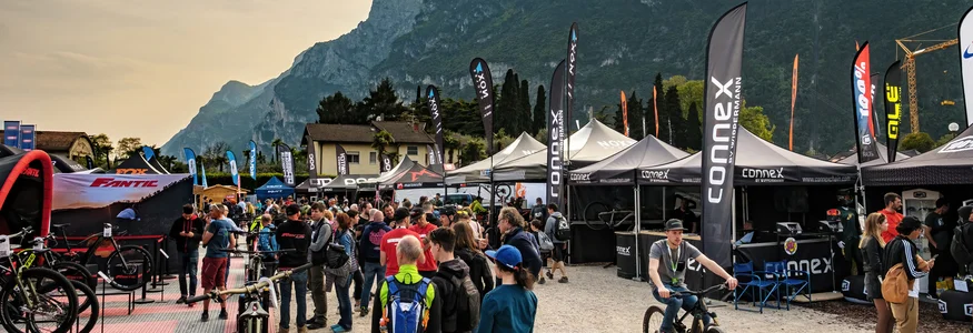 Menschen auf einer Fahrradmesse mit Bergen im Hintergrund